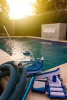 Pool cleaning and maintenance kit, Cleaning and maintenance tools on the edge of the pool. vacuum cleaner, ph test, skimmer and pool sweeper photo