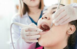 Patient checked by dentist, Dentist doing dental checkup, Close up of dentist checking patient with excavator and dental mirror, Dentist checking patient with excavator and dental mirror photo