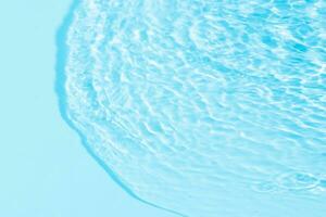 Blue water with ripples on the surface. Defocus blurred transparent blue colored clear calm water surface texture with splashes and bubbles. Water waves with shining pattern texture background. photo