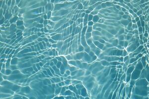 Blue water with ripples on the surface. Defocus blurred transparent blue colored clear calm water surface texture with splashes and bubbles. Water waves with shining pattern texture background. photo