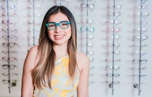 Portrait of happy girl in glasses in an eyeglasses store. Smiling happy girl in eyeglasses with store eyeglasses background photo