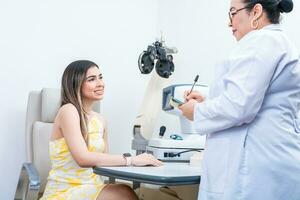 optometrista con hembra paciente tomando notas en oficina. hembra paciente teniendo consulta con optometrista en oficina foto