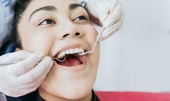 Close-up of the hands of a dentist cleaning the teeth of a female patient, Hands of a specialist dentist cleaning the teeth of a female patient. Close up of dentist hands cleaning patient teeth photo