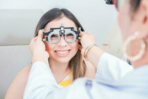 Vision check with optometrist trial frame on patient. Doctor checking vision of patient with trial frame in ophthalmology clinic photo