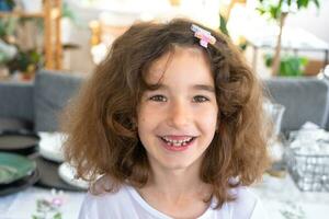 Toothless happy smile of a girl with a fallen lower milk tooth close-up. Changing teeth to molars in childhood photo