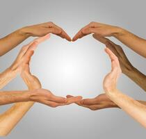 Hands make heart shape on a gray background photo