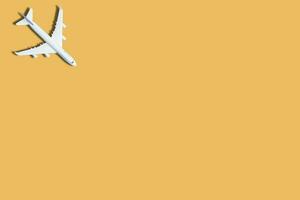 Miniature toy airplane on yellow background. Trip by airplane. photo