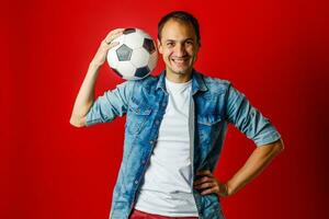 Handsome man holding a soccer ball over colorful backgound photo
