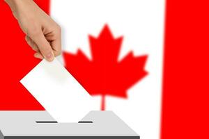 hand drops the ballot election against the background of the Canada flag, concept of state elections, referendum photo