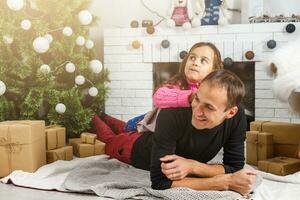 alegre Navidad y contento vacaciones. familia preparación cerca el Navidad árbol a hogar foto