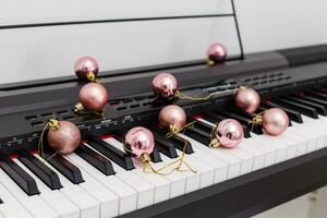 Piano keyboard with Christmas decoration, closeup photo