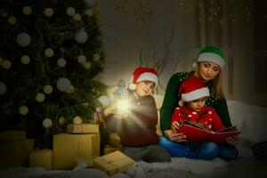 children read a book near a Christmas tree at Christmas at home photo