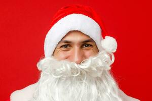 Santa Claus looking into the camera with traditional background and hands crossed in front of him photo