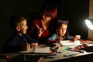 children with mom do their homework at night photo