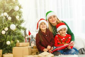 madre gasto hora con hijas cerca Navidad árbol foto