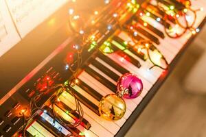 Piano keyboard with Christmas decoration, closeup photo