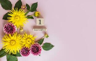 Festive autumn background with beautiful autumn flowers, a calendar with a date for the beginning of the school year. Top view. A copy of the space. photo