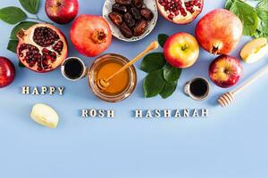 New Year's holiday background for Rosh Hashanah. traditional treats for the holiday. Top view. Blue background. Text of Blessed Rosh Hashanah. photo