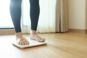 Lose weight. Fat diet and scale feet standing on electronic scales for weight control. Measurement instrument in kilogram for diet. photo