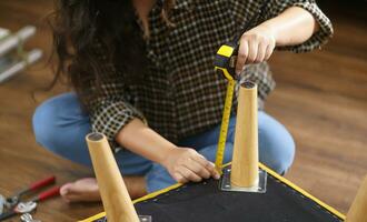 Asian Woman self repairs furniture renovation using equipment to diy repairing furniture sitting on the floor at home photo