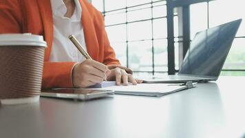 Asian Business woman using calculator and laptop for doing math finance on an office desk, tax, report, accounting, statistics, and analytical research concept video