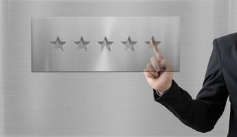 evaluation and classification concepts. Businessmen represented by hand rise on increasing five stars on metal background photo