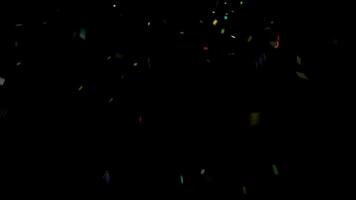Colorful confetti explodes on a black background video