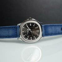 Surabaya, IDN, 2023 - Product photo of a luxury watch with a blue jeans canvas strap with a shiny white board background