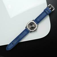 Surabaya, IDN, 2023 - Product photo of a luxury watch with a blue jeans canvas strap with a shiny white board background