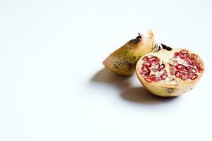 tasty red healthy juicy pomegranate fruit cut in half isolated on white photo