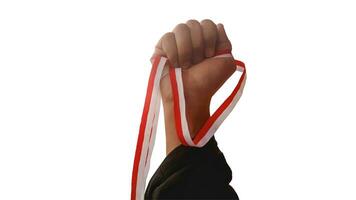 The hands of a man holding a red and white ribbon as a symbol of the Indonesian flag. Isolated on white background photo