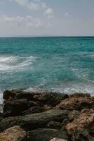 rocoso playa en mallorca, en verano a alto marea con el olas golpear y rotura en el costa. foto