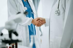 Doctor, handshake and partnership in healthcare, medicine or trust for collaboration, unity or support.Team of medical experts shaking hands in teamwork for or success in clinic or hospital photo