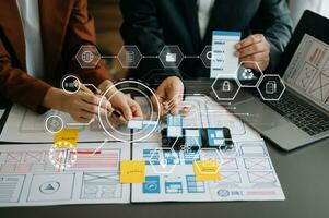 UX developer and ui designer brainstorming about mobile app interface wireframe design with customer breif and color code at modern office. on virtual  screen. photo