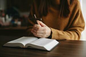 Woman praying on holy bible in the morning.Woman hand with Bible praying. Christian life crisis prayer to god. in sun lightWoman praying on holy bible in the morning.Woman hand with Bible praying. photo