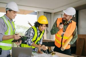 Engineers are discussing data working and laptop or tablet with architectural project at new construction site on big project. photo