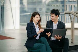 Businesswoman and man walking and talking on street in city Outside Office with ,young couple discussing and drinking coffee together, partners, teamwork photo