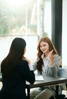 Female discussing new project with male colleague. Mature woman talking with young woman in office. photo