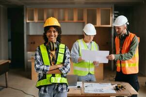 Architect caucasian man and woman working with colleagues mixed race in the construction site. Architecture engineering on big project. Building in construction process interior. photo