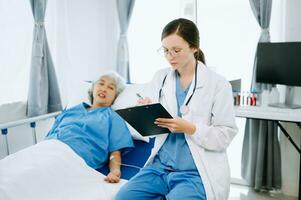 caucásico médico sonriente tomar cuidado de un mayor paciente en hospital. simpático enfermero o terapéutico tratar cliente profesional médico Servicio concepto. foto