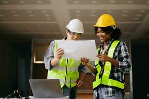 Architect caucasian man and woman working with colleagues mixed race in the construction site. Architecture engineering on big project. Building in construction process interior. photo
