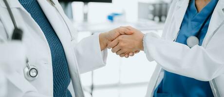 Doctor, handshake and partnership in healthcare, medicine or trust for collaboration, unity or support.Team of medical experts shaking hands in teamwork for or success in clinic or hospital photo