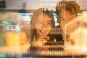 Young Asian couple enjoying their dessert in a coffee shop. photo