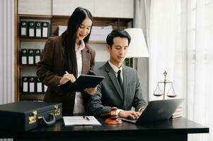 Asian business team and lawyers discussing contract papers sitting at the table. Concepts of law, advice, legal services. at modern office photo