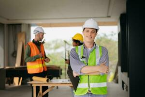 Contractor and architect looking at plan, tablet, laptop and talking about working on big project. Building in construction process interior. team work photo