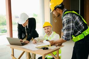Architect caucasian man working with colleagues mixed race in the construction site. Architecture engineering on big project. Building in construction process photo