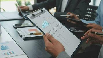 Teamwork with business people analysis cost graph on desk at meeting room. video