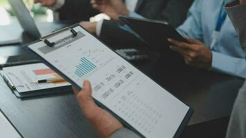 Teamwork with business people analysis cost graph on desk at meeting room. video