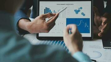 presente squadra di affari finanziari. le mani dell'uomo d'affari tengono i documenti con la foto di riserva di statistica finanziaria, la discussione e l'analisi riportano i dati dei grafici e dei grafici. concetto finanziario di finanza video