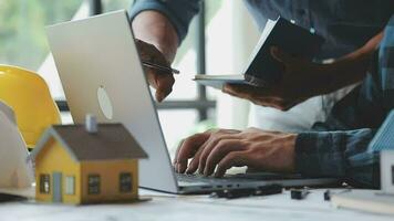 Image of team engineer checks construction blueprints on new project with engineering tools at desk in office. video